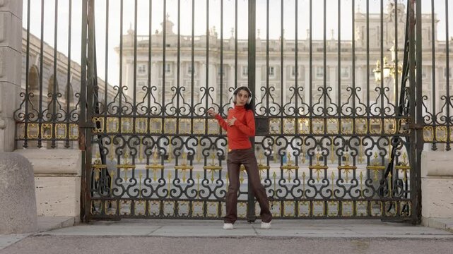 Happy energetic woman dancing in front of the royal palace of Madrid