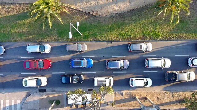 Traffic congestion on a busy urban road with multiple cars moving slowly. Ideal for concepts related to traffic jams, commuting, transportation problems, urban mobility, pollution, rush hour, and city