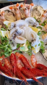 preparazione crudo di mare in un piatto con ghiaccio sul bancone di una pescheria