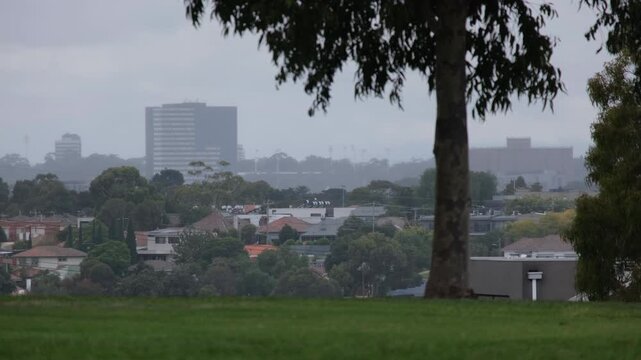 Overcast suburban skyline in Melbourne, Australia, with residential houses and buildings under grey sky. Soft damp atmosphere, a muted urban landscape, weather, living and moody city environment.