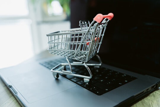 Miniature shopping cart on a laptop keyboard, a symbol of E-commerce