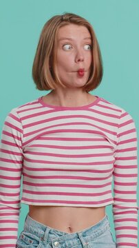 Surprised funny comical playful young woman making fish grimace pout lips, smooching choking and looking with shocked dumb idiotic expression. Lovely female lady doing crazy duck face, fooling around