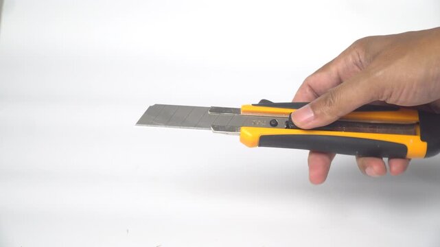 Close-Up of Hand Sliding Utility Knife Blade Open on White Background
