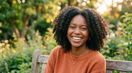 Fototapeta premium Happy African American Woman with Curly Hair Smiling in a Sunny Outdoor Garden