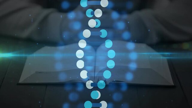 Vertical video: Sparking particles, helix rising above book on desk, hands folded in light hoody