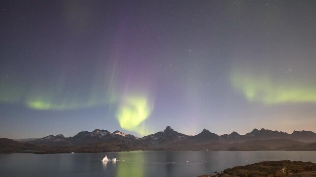 Timelapse of Northern Lights, Aurora Borealis dancing over ice fjord of East Greenland