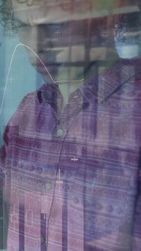 Vertical video: Man leaning forward analyzing market trends as animated line charts overlaying face