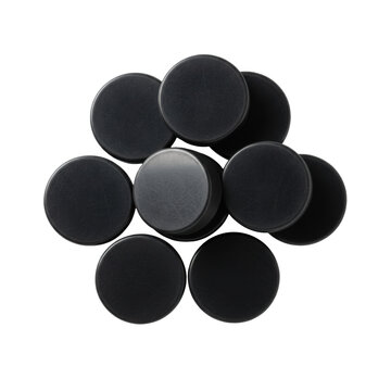 Eight black vulcanized rubber ice hockey pucks arranged in a creative collage on a white studio background with soft shadows concept of professional sports equipment