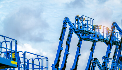 Articulated boom lift. Aerial platform lift. Telescopic boom lift against blue sky. Mobile construction crane for rent and sale. Maintenance and repair hydraulic boom lift service. Crane dealership. © Fahroni