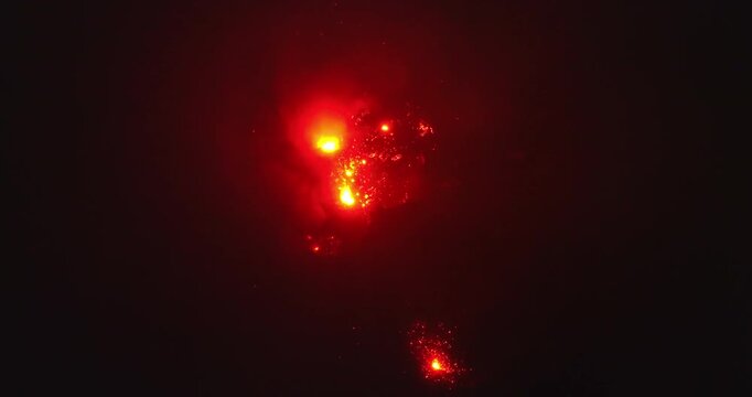 Mount Yasur volcano on Tanna Island erupting with bright red molten lava and fiery explosions against the dark sky at night, showcasing powerful natural destruction. Aerial view top down drone shot