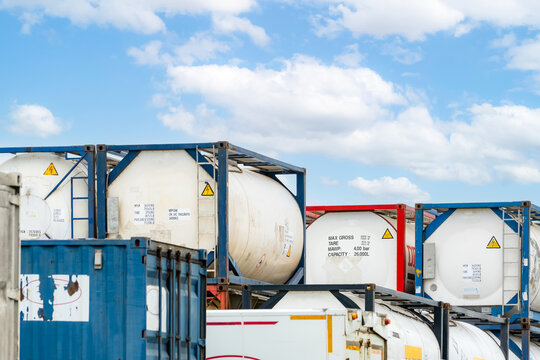 Chemical tank container. ISO tank container for chemical delivery. Bulk liquid transport. Chemical company. Container freight area. Global logistics business. Chemical container for truck transport.