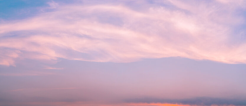Dramatic pink sunset sky with soft clouds forming abstract pastel background in evening, serene nature scene capturing calm relaxing mood and romantic love concept with gentle light and dreamy horizon
