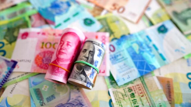 Chinese yuan, US dollars among various currencies background. Banknotes different countries denominations. Chinese yuan, US dollars and foreign currencies. World's reserve currency in global trade.