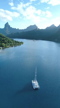 Boat anchored in Opunohu bay, with mountains in background