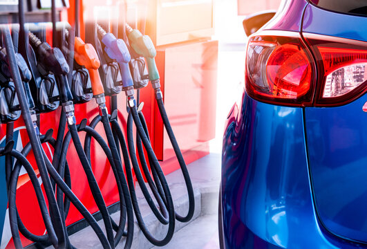 Blue luxury SUV car fueling at gas station. Refuel fill up with petrol gasoline. Petrol pump filling fuel nozzle in gas station. Petrol industry and service. Petrol price and oil crisis concept.