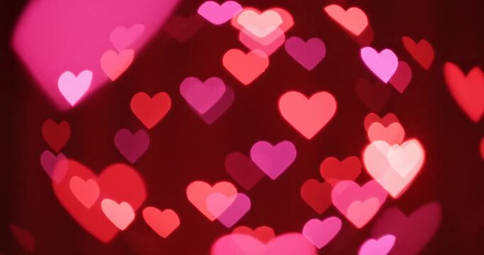 Colorful hearts floating in a soft-focus background with a vibrant red curtain ambiance