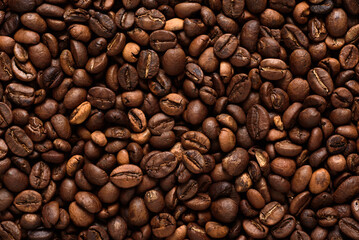 Obraz premium Top view of medium roast coffee beans texture background. High quality roasted arabica coffee beans for background and wallpaper