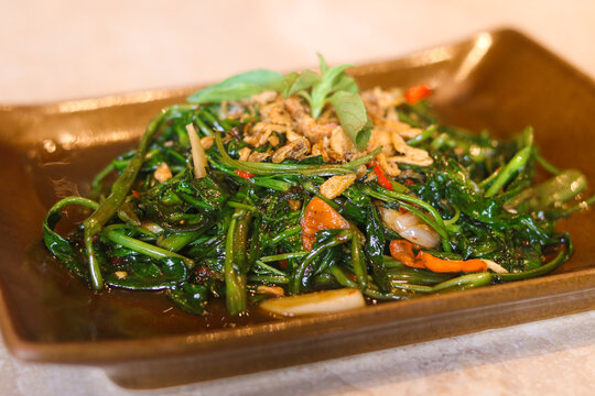 A vibrant plate of stir-fried water spinach with shrimp paste (Kangkung Terasi).