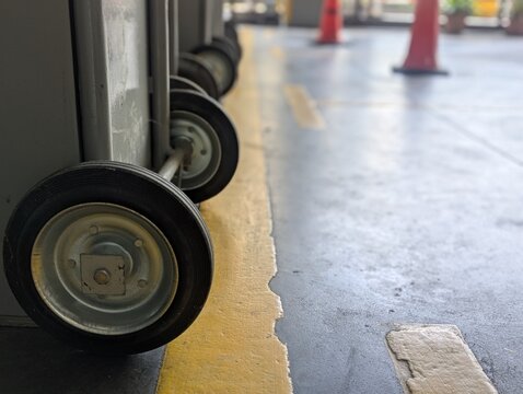 Close-up of heavy-duty rubber wheels on a retractable metal security gate in an industrial warehouse.