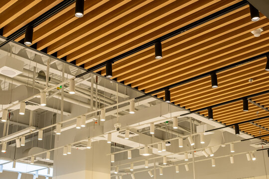 Modern industrial ceiling with wooden panels and hanging lights