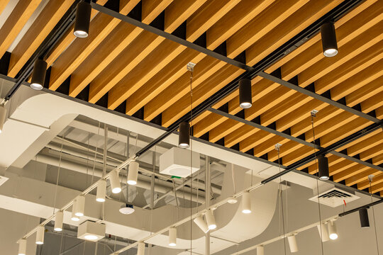 Modern commercial interior ceiling with exposed pipes, LED lighting, air ducts, sprinkler system and CCTV, clean industrial design with structured architecture and lighting layout