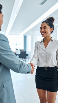 Professional Businesswoman Shaking Hands with Colleague in Modern Office Environment.