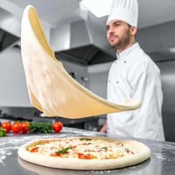 Professional Chef Tossing Pizza Dough in a Modern Kitchen.