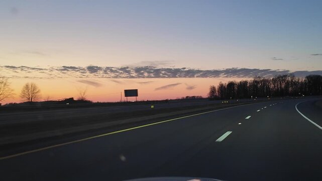 Driving Down Highway at Sunset With Curved Road and Landscape