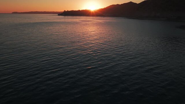 Low tilting-up aerial shot of the sunset over Point Dume in Malibu, California. 4K