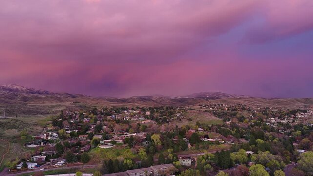Wide shot across foothills of sunset clouds