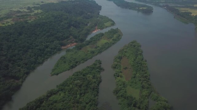 Slow aerial movement over the Karli River backwaters surrounded by lush green forested islands and sandbars in Devbag, Malvan, Maharashtra, India.