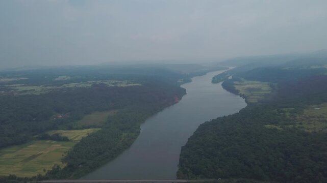 Overhead footage capturing the serpentine Karli River flowing through verdant wetlands in Sindhudurg's Malvan region, Maharashtra, India