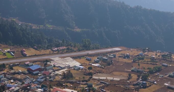Aerial shot of dangerous Lukla Airport Everest Nepal showing the short mountain runway surrounded by rugged Himalayan terrain and settlement known as the gateway to Sagarmatha