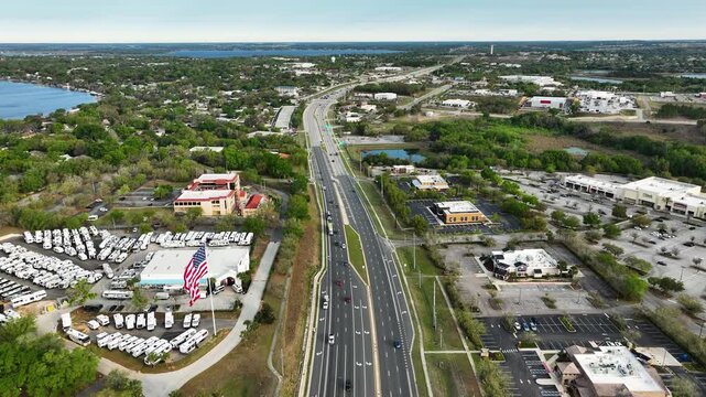 A high-angle drone view features a bustling intersection along Highway 27 in Central Florida, framed by businesses and open landscape.