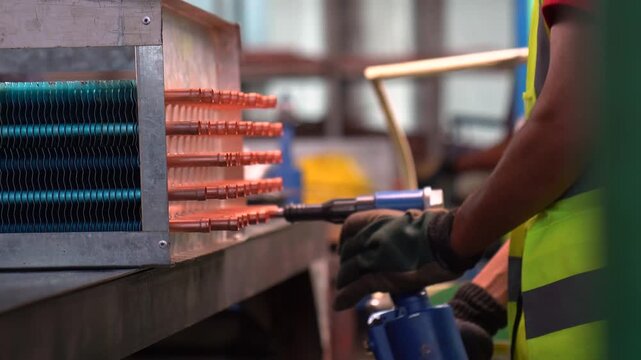Worker Of A Metalworking Factory Using A Pneumatic Drill To Ream The Hole Of Copper Pipes.