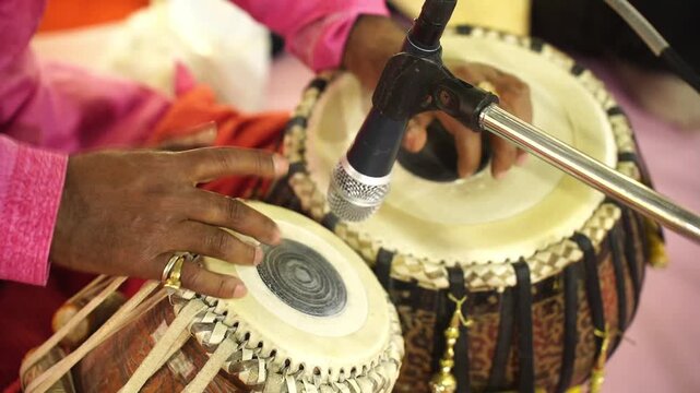Close-up of a skilled artist's hands playing the tabla at a live musical event, showcasing traditional South Asian rhythmic art.