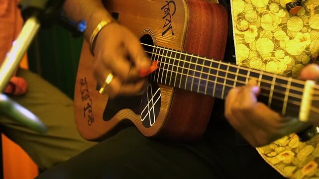 A Bengali man performing with his acoustic guitar in Kolkata 