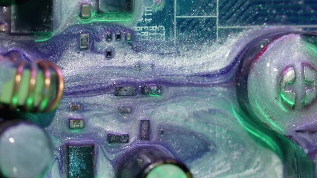 Electronic circuit. Glitter paint. Defocused purple green neon color round sparkling water texture spill on abstract art digital background.
