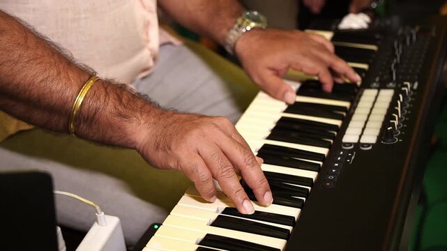 A band artist playing a synthesiser piano at a function in India