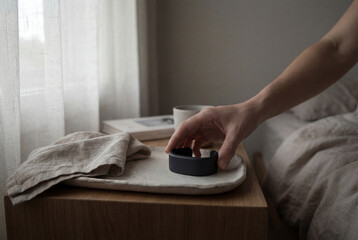 Fototapeta premium Woman's hand picking up a black ring from a tray