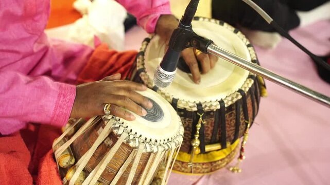 Professional Indian musician performing the tabla, a traditional percussion instrument, during a festive wedding ceremony in India