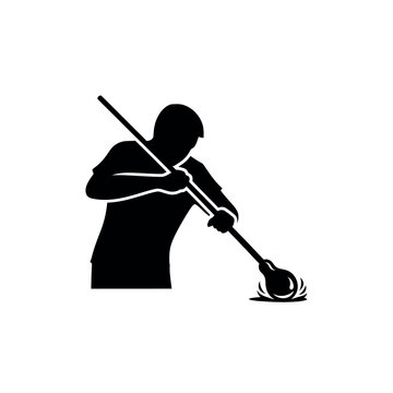 Silhouette of a glassblower shaping molten glass with a tool.