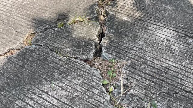 Close up of deep crack on weathered concrete road