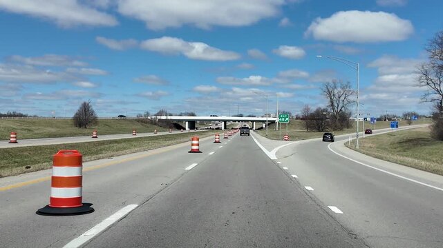 Driving on Highway Past Construction Pylons on a Sunny Day
