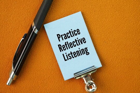 Pen and paper with the words Practice Reflective Listening. empathetic, active communication technique where the listener carefully hears, understands.