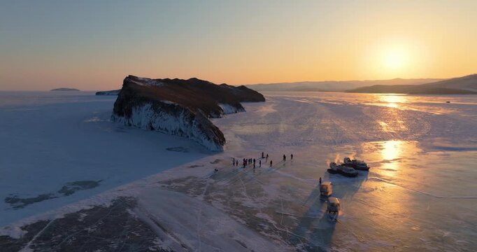Ogoy island in winter Baikal lake, Siberia, Russia. Aerial view. Tourists walking around the island. Cars and hovercrafts ride on the ice. Winter landscape