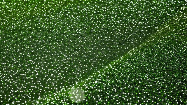 Close up of green leaf surface covered with sparkling water droplets in natural light