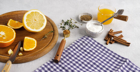 Orange, lemon and cinnamon sticks on the kitchen table with blue napkin, copy space © Taborisova