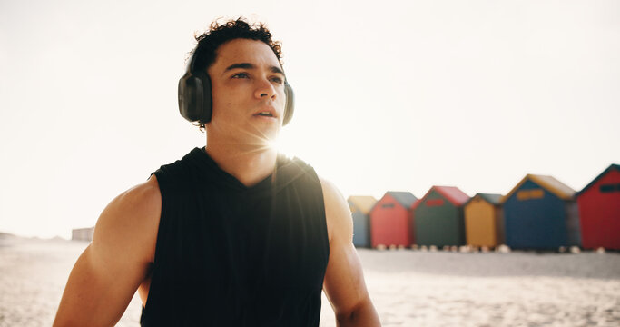 Athlete, thinking and man with headphones at beach, fitness or memory of wellness with music playlist. Outdoor, runner and person with tech for audio, resting and reflection after exercise and flare