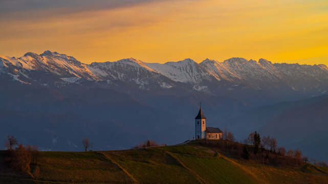 Sunrise at Jamnik Church in Slovenia with pastel sky and alpine landscape